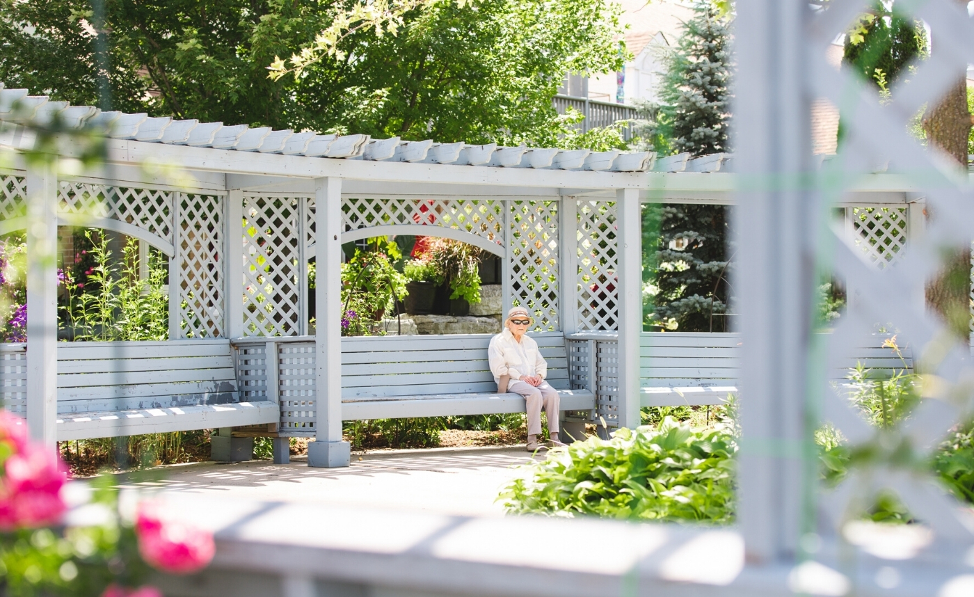 lady sitting on a bench near the garden 