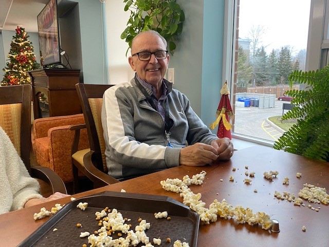 Image of resident stringing popcorn for the holiday season.