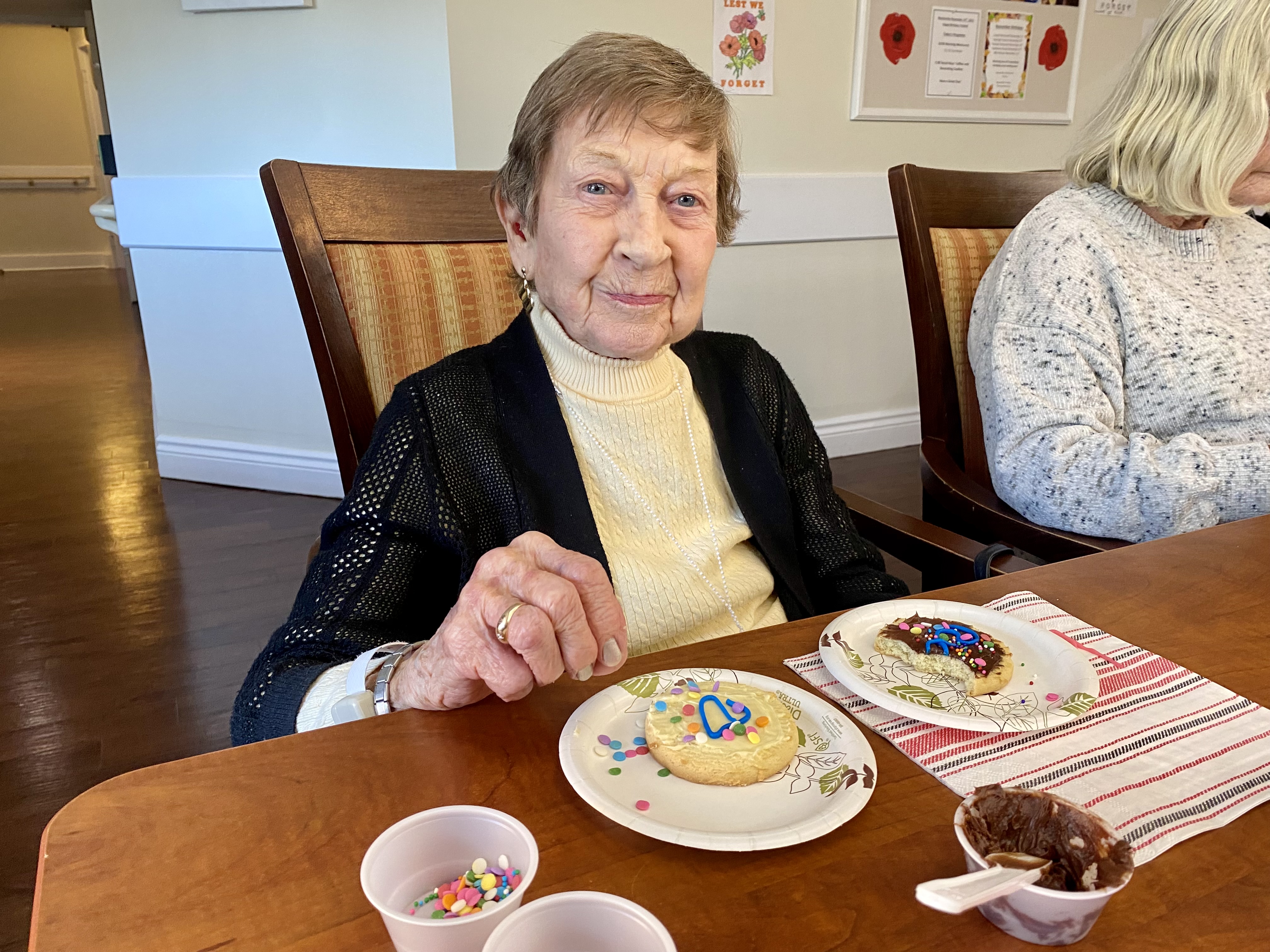 Image of resident decorating cookies smiling at camera.