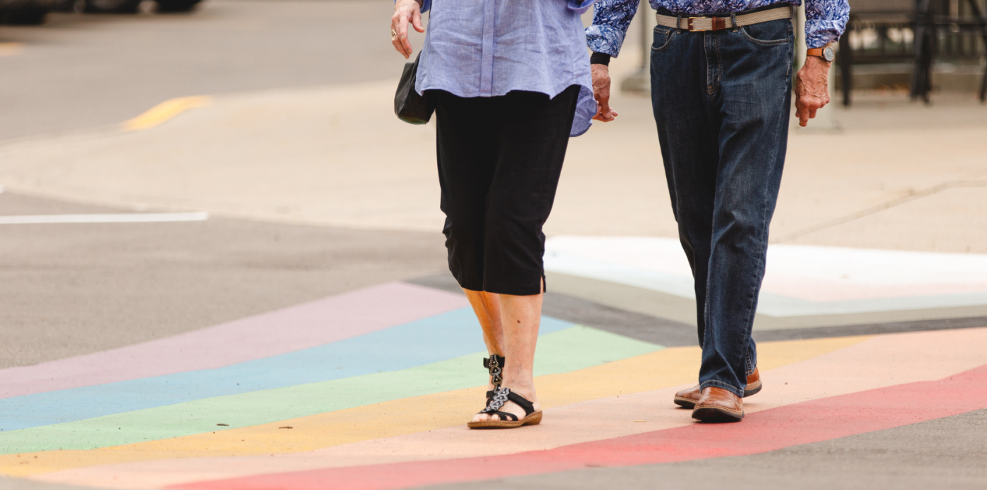 Residents walk across painted progress flag at Luther Village on the Park